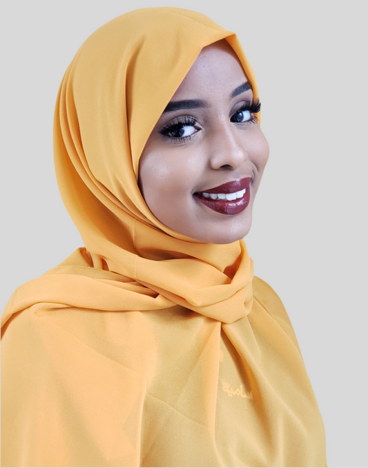 ZIZI chiffon hijab in mustard yellow worn by smiling woman with flawless makeup