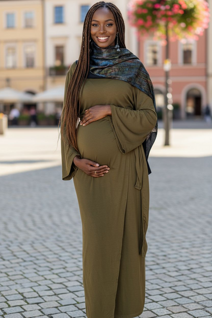 Pregnant Woman in a green dress standing on a street with blurred background