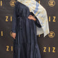 Woman in a navy blue dress with a patterned scarf standing in front of a Zizzi branded backdrop.