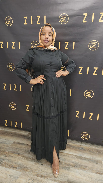 Woman wearing black Hodan Lace Maxi Dress from ZIZI Boutique with button-down front and long sleeves