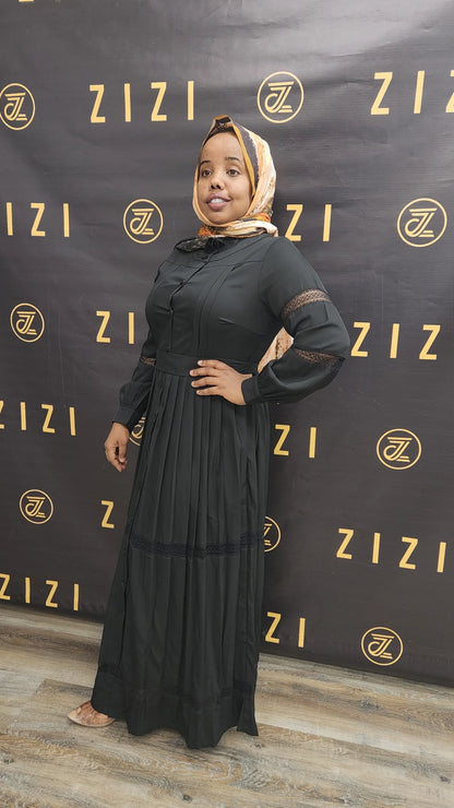 Woman wearing black Hodan Lace Maxi Dress from ZIZI Boutique with lace details on sleeves and flowing skirt