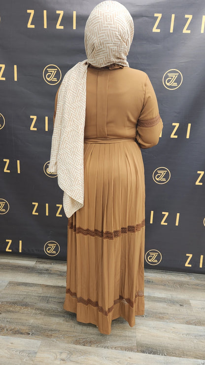 Back view of woman wearing Hodan Lace Maxi Dress in brown from ZIZI Boutique with pleated skirt and lace detailing