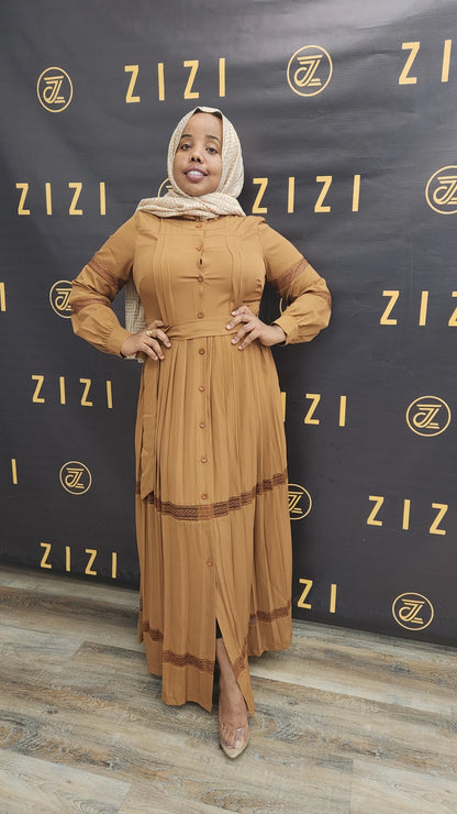 Woman wearing a brown Hodan Lace Maxi Dress from ZIZI Boutique with full sleeves and button details