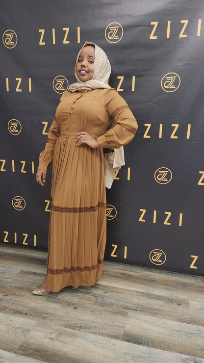 Woman wearing Hodan Lace Maxi Dress in brown by ZIZI Boutique with long sleeves and lace details