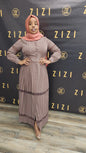 Woman wearing a Hodan Lace Maxi Dress in muted mauve color standing against ZIZI Boutique backdrop