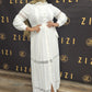Woman wearing a white Hodan Lace Maxi Dress by ZIZI Boutique with lace details and a front slit