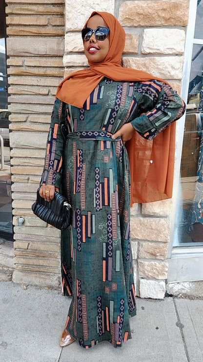 Zoraa Summer Print Maxi Dress in green geometric pattern worn with rust hijab and black clutch