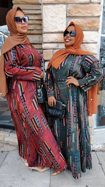 Two women wearing Zoraa Summer Print Maxi Dress in red and green with brown hijabs and sunglasses outdoors