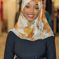 Smiling woman wearing ZIZI Boutique chiffon print hijab Carmel Yellow Light Blue Ink Blots with a stylish dark outfit