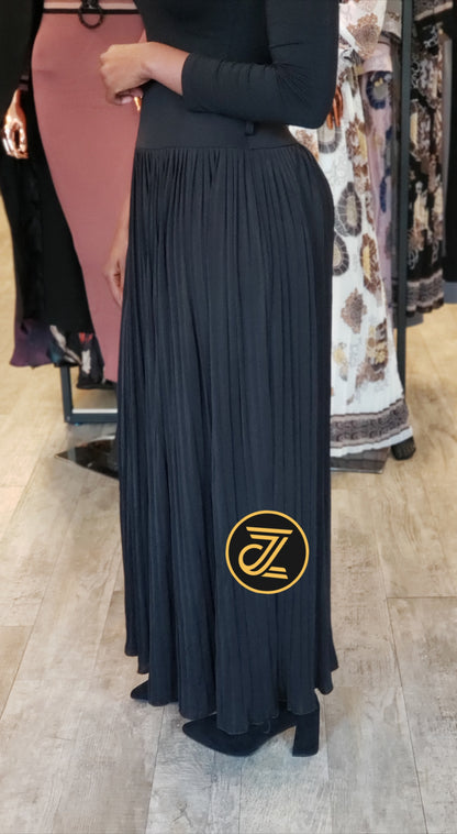 High waisted women's maxi pleated skirt in black worn with long sleeve top and boots