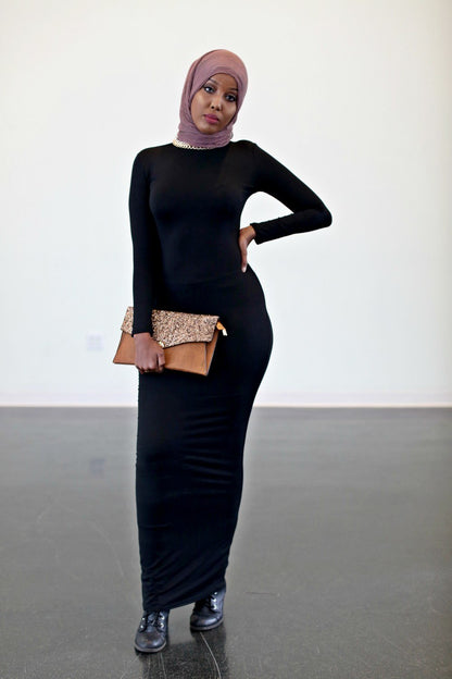 Model wearing a black Bodycon Zipper Maxi Dress Shapewear ZIZI Boutique with a stylish clutch and sneakers