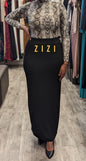 Woman wearing Essential Jersey Maxi Skirt from ZIZI Boutique with a stylish top in a boutique setting