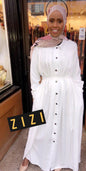 Woman wearing a white pleated button down dress with long sleeves and a waist tie by ZIZI Boutique