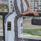 Woman wearing Satin Silk Maxi Print Dress Shirt by ZIZI Boutique with black and white patterns and holding a black handbag