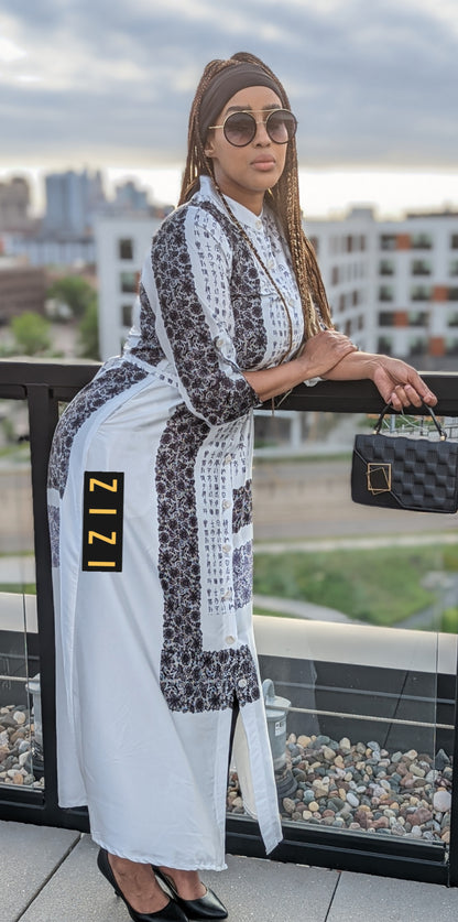 Woman wearing Satin Silk Maxi Print Dress Shirt by ZIZI Boutique with black and white patterns and holding a black handbag