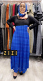 ZIZI Slant Maxi Dress Royal Blue worn by woman with scarf standing in front of colorful dresses